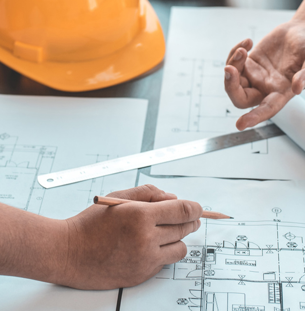 Engineers going over plans with pencil and hardhat