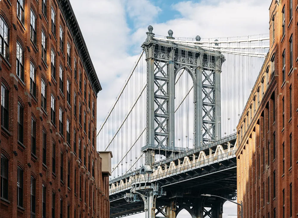 New York city street buildings with Manhattan bridge in the background