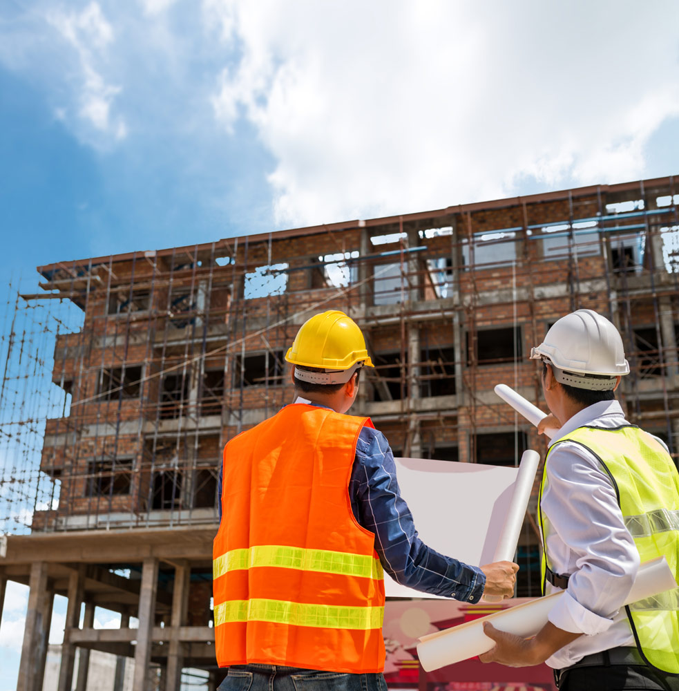 Workers holding blueprints and looking at new construction