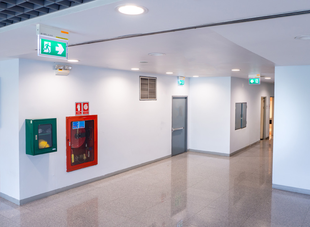 Building hallway with fire alarms and exit signs